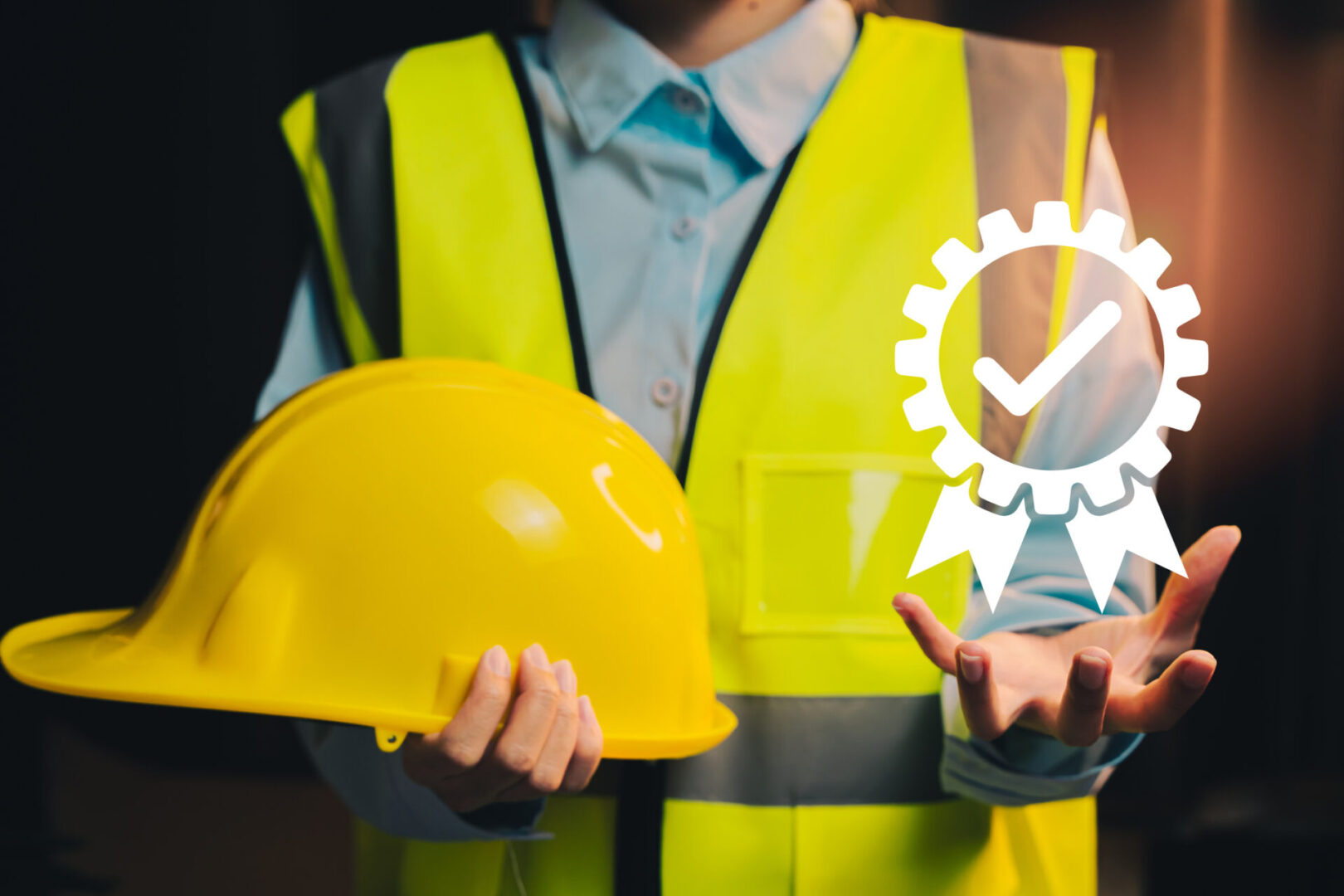 Person holding hard hat and safety badge.