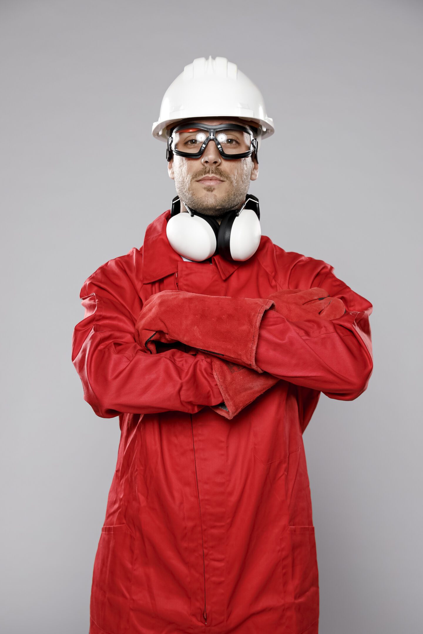 Confident worker in red coveralls with safety gear.