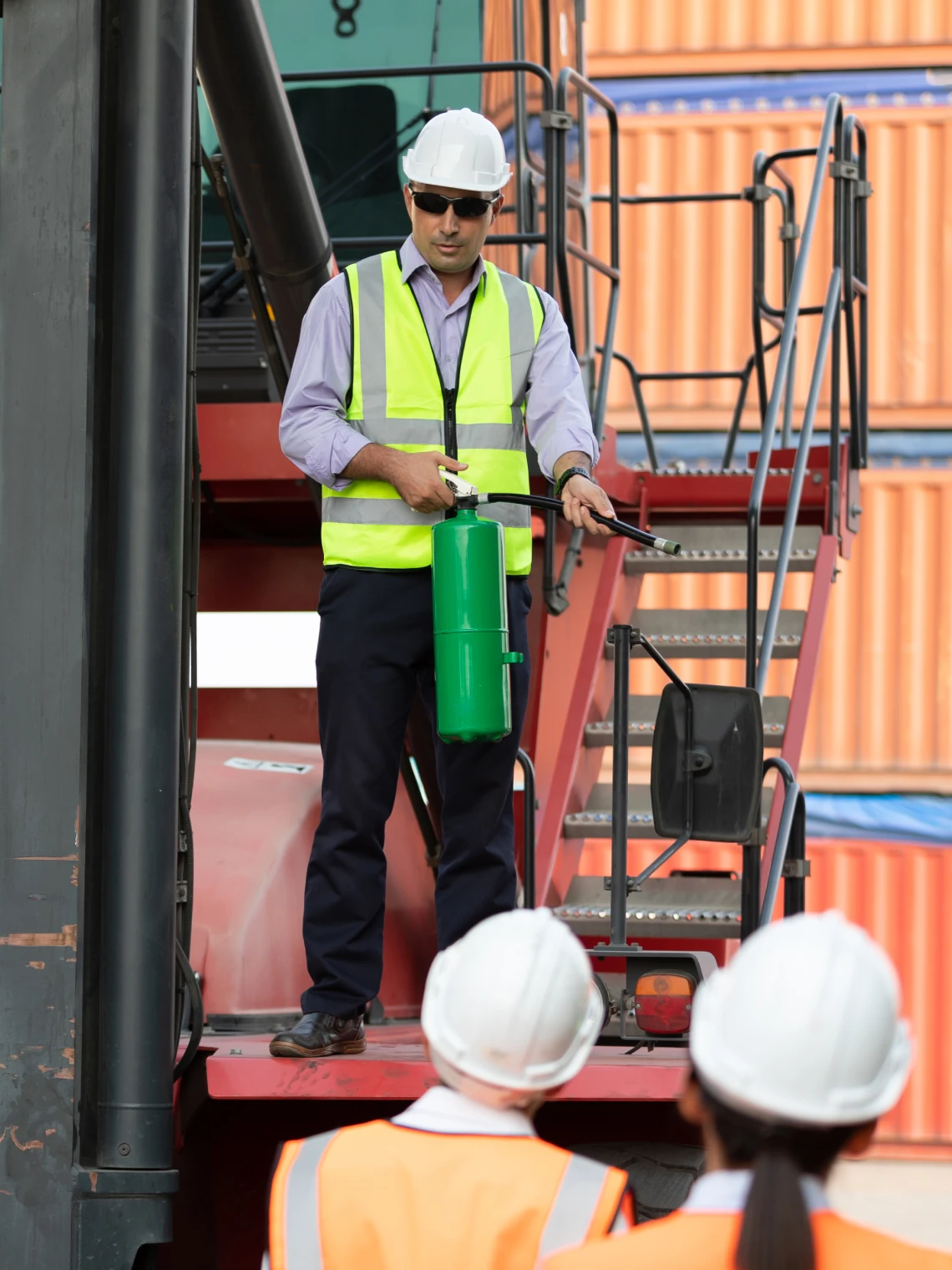 Construction worker demonstrating with fire extinguisher.